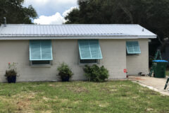 Home exterior with hurricane shutters on the windows